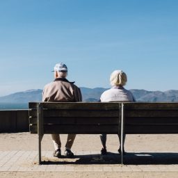 Older couple sitting on a bench together.