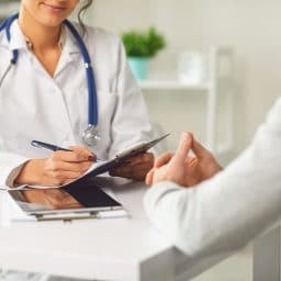 Doctor talking with a patient in a medical office.