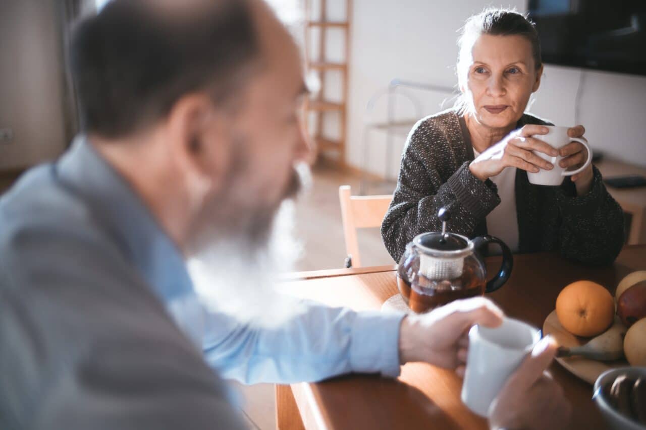 Husband and wife having coffee together at the breakfast table.