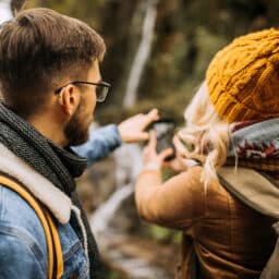 A young couple hiking in the mountains. Man is wearing hearing aids.