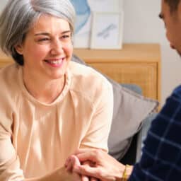 Man talking to his mom, holding her hand