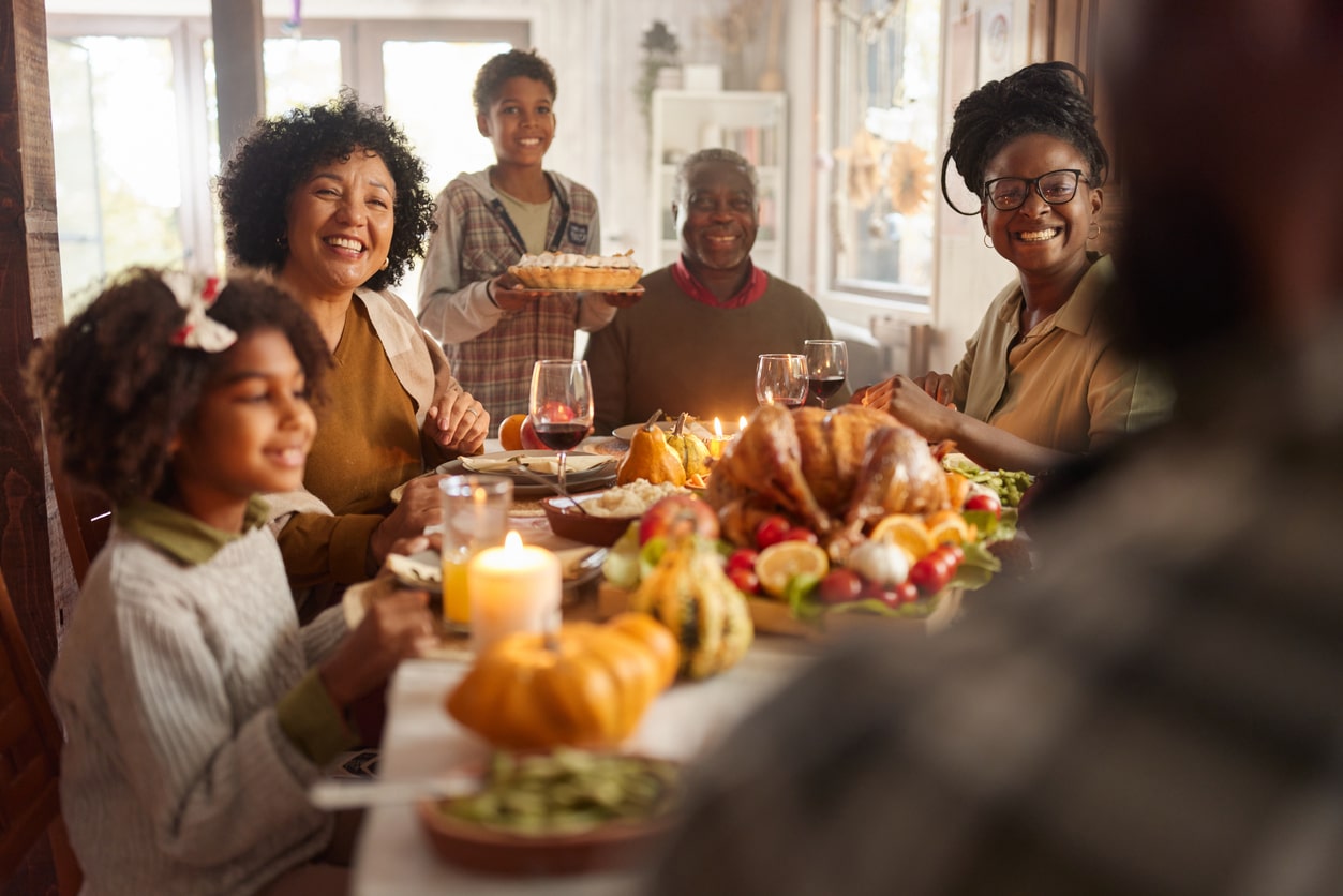 Happy extended family having a meal on Thanksgiving at home.