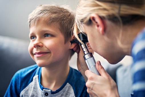 Young boy getting an ear exam.