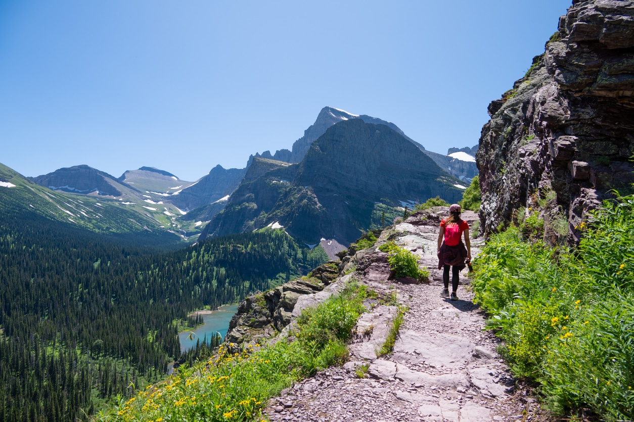 Hiker Walking Along Mountain Trail in Glacier National Park.